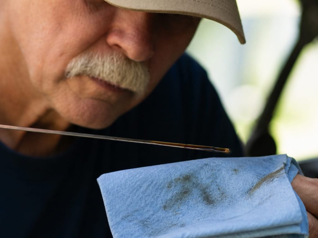 man checking oil level on dipstick