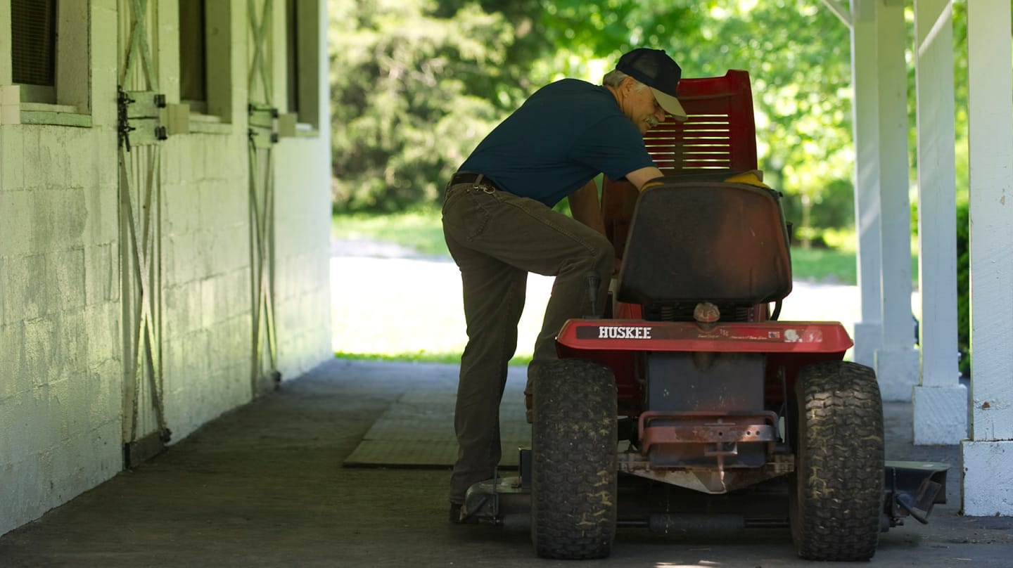 man working on riding mower