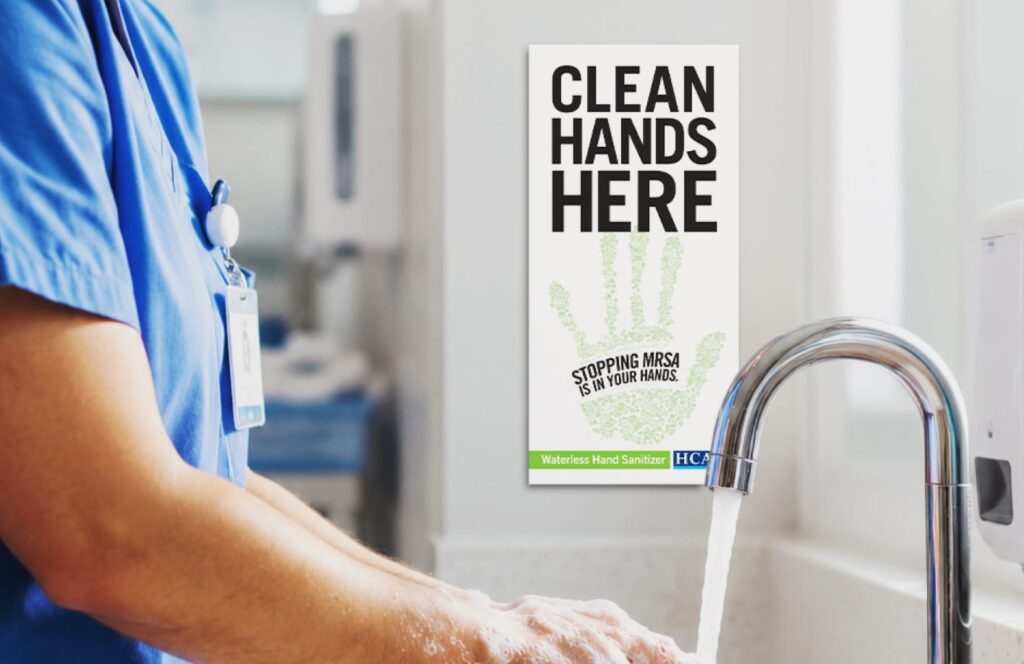 handwashing station with nurse washing hands in front of MRSA awareness poster